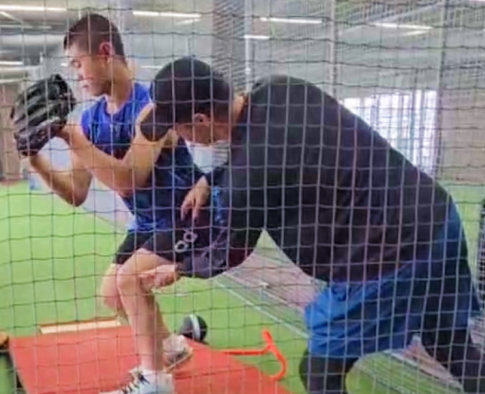 指導者が選手のフォームを矯正する様子